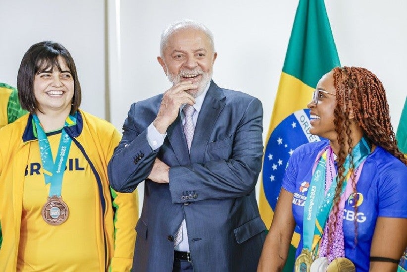 O presidente Lula entre Bruna Alexandre, primeira atleta paralímpica do Brasil a disputar Jogos Pan-Americanos entre os olímpicos, e a campeã mundial e olímpica Rebeca Andrade. Foto: Ricardo Stuckert / PR