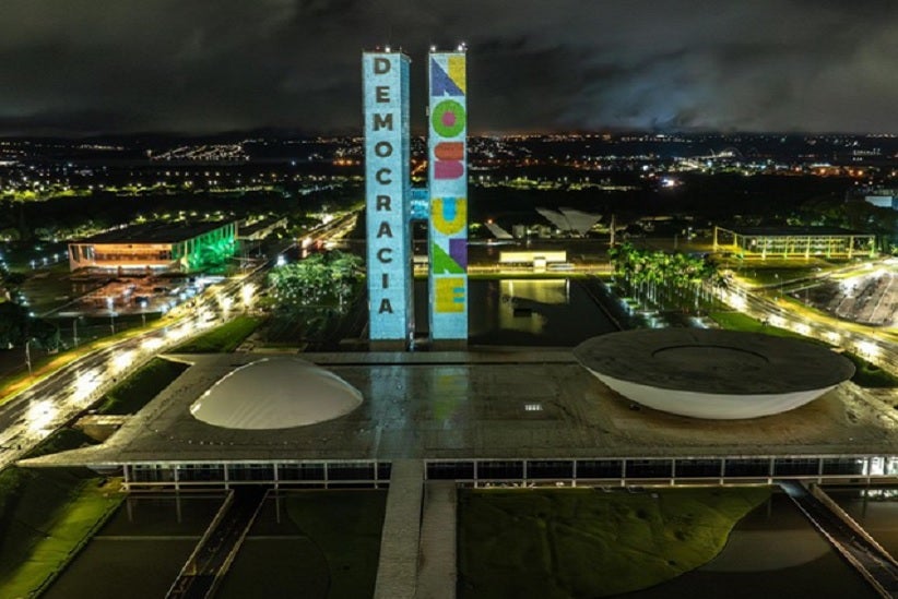 Visão da sede dos três poderes em Brasilía e a projeção da bandeira nacional nas torres do Congresso - Foto: Audiovisual/PR