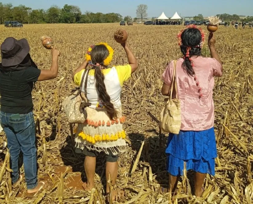 Anciãs Guarani Kaiowá rezam na direção dos capangas armados que ameaçam a comunidade nas retomadas da região de Douradina. Foto: Comunicação da Aty Guasu