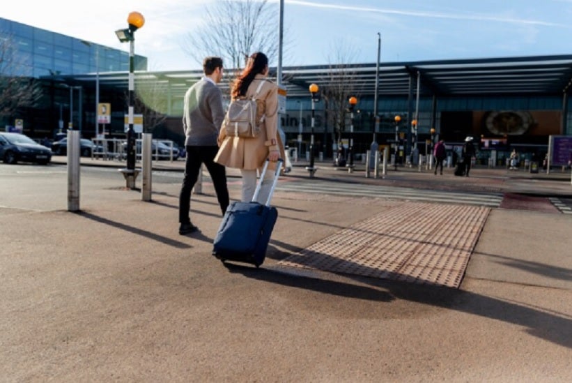 Descrição da Imagem (ALT) - Um casal caminhando em direção ao aeroporto Fonte: freepik